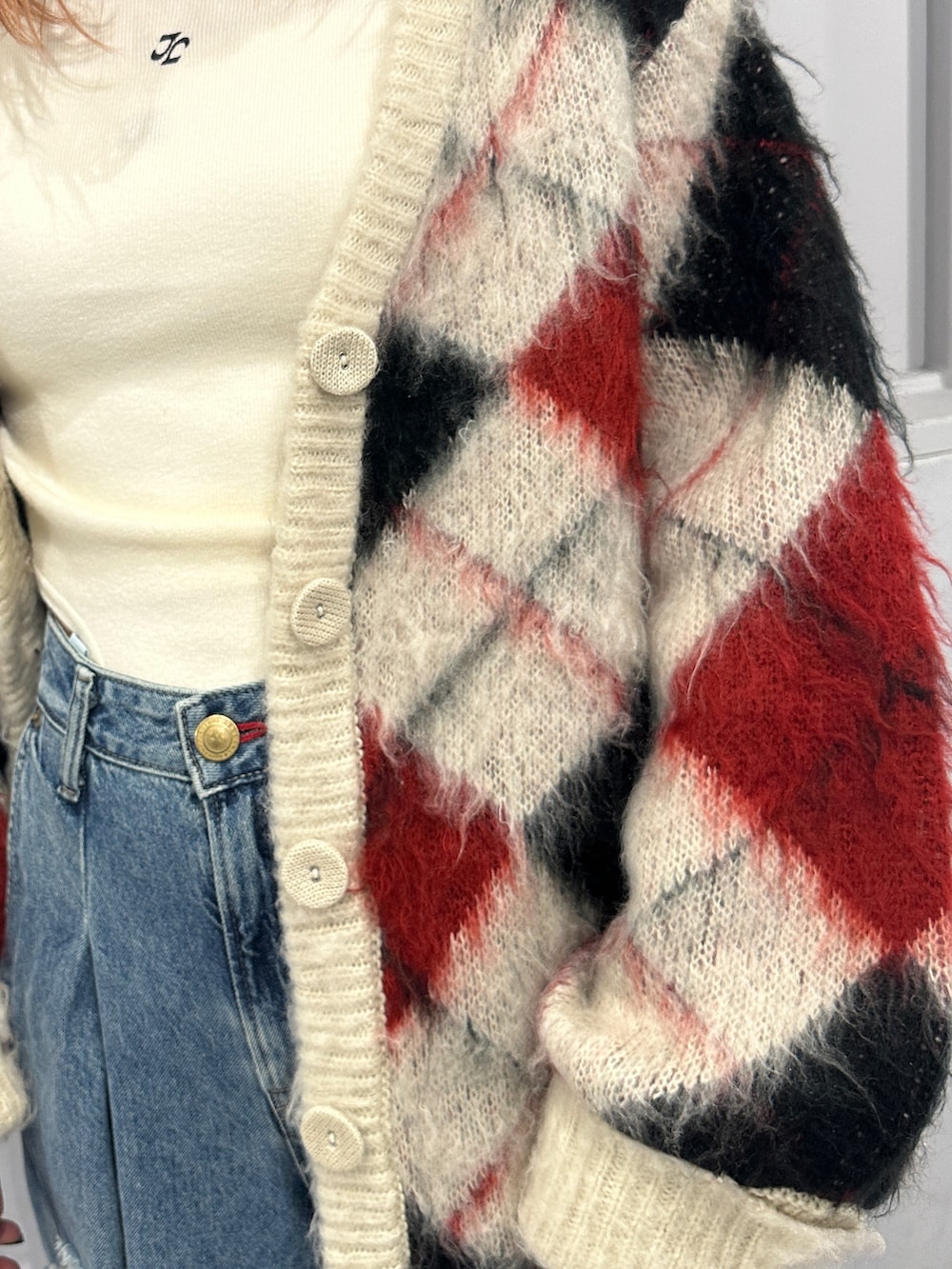 ブルー系のデニムパンツ、ホワイト系のカーディガン/ボレロ、ホワイト系のニット/セーターを着用したレディースの秋コーディネートの9枚目の写真