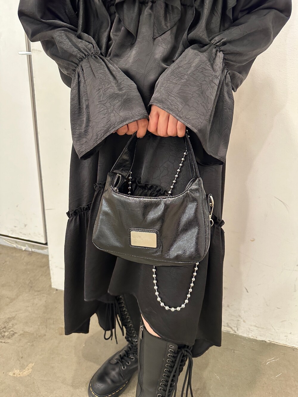 ブラック系のワンピース、ブラック系のハンドバッグ、ブラック系のブーツを着用したレディースの秋コーディネートの9枚目の写真