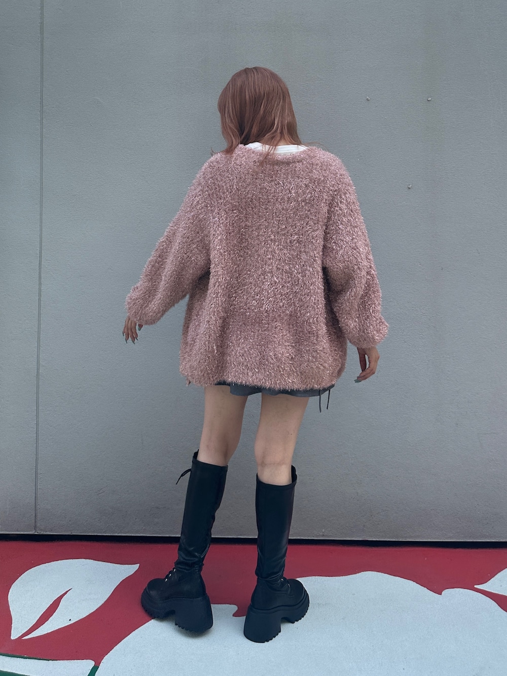 グレー系のスカート、ブラック系のブーツ、ホワイト系のTシャツ/カットソーを着用したレディースの夏コーディネートの3枚目の写真