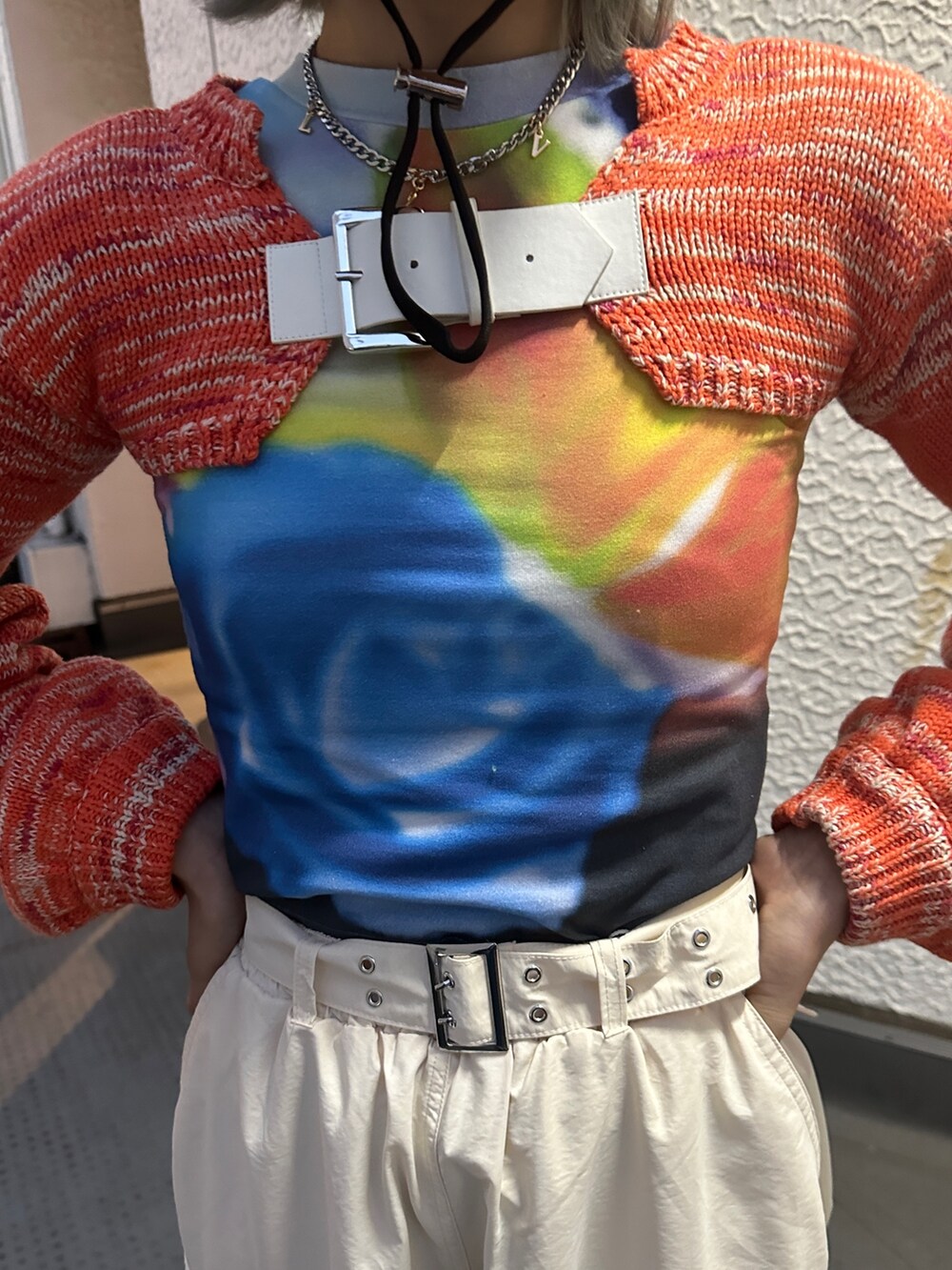 イエロー系のその他パンツ、オレンジ系のニット/セーター、ブラック系のTシャツ/カットソーを着用したレディースの冬コーディネートの8枚目の写真