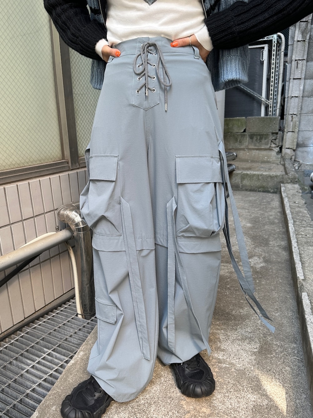 グレー系のその他パンツ、ホワイト系のTシャツ/カットソー、ブラック系のニット/セーターを着用したレディースの秋コーディネートの10枚目の写真