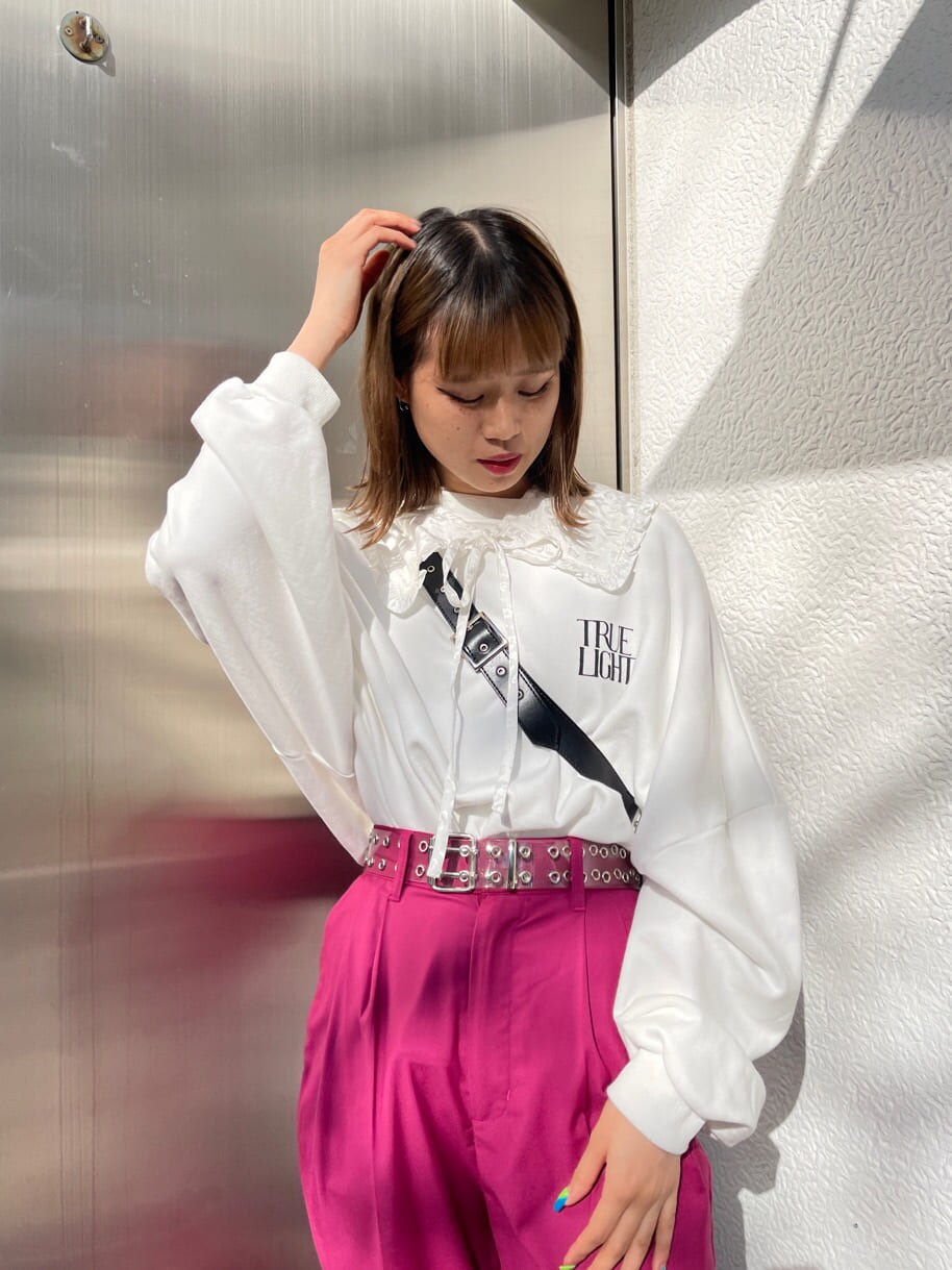 ピンク系のスラックス、ブラック系のショルダーバッグ、ホワイト系のスウェットを着用したレディースの冬コーディネートの4枚目の写真