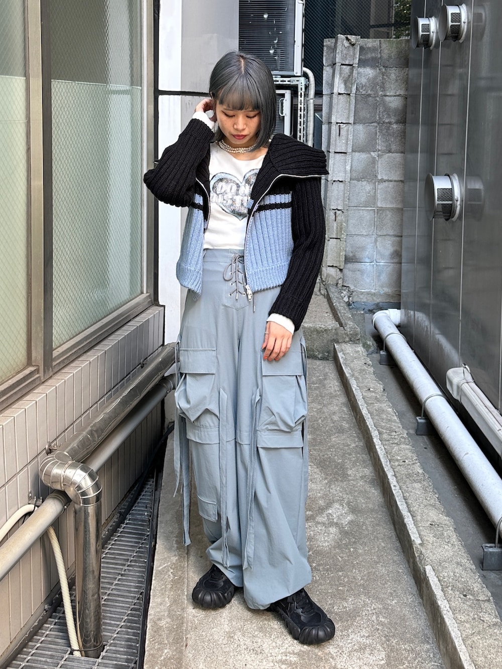 グレー系のその他パンツ、ホワイト系のTシャツ/カットソー、ブラック系のニット/セーターを着用したレディースの秋コーディネートの3枚目の写真