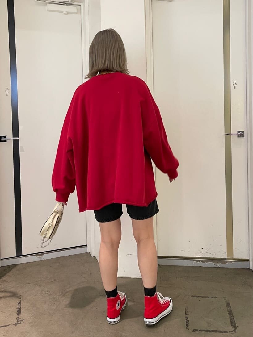 レッド系のスニーカー、ブラック系のデニムパンツ、レッド系のスウェットを着用したレディースの春コーディネートの5枚目の写真