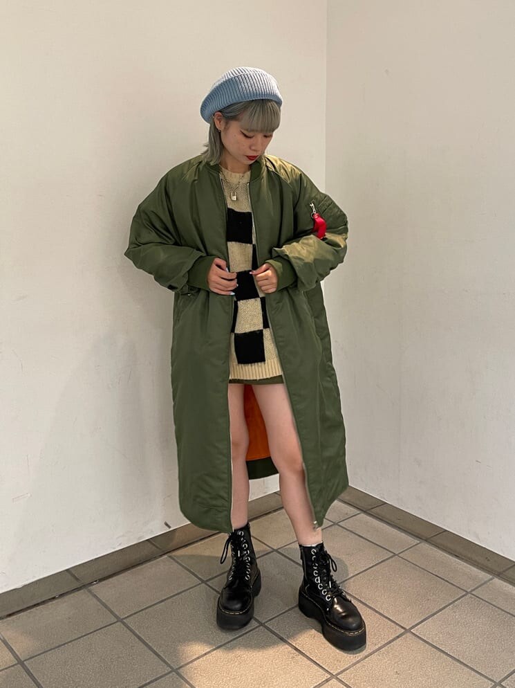 ブラック系のニット/セーター、グリーン系のMA-1、グリーン系のスカートを着用したレディースの秋コーディネートの3枚目の写真
