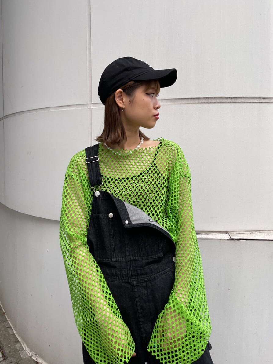 ブラック系のサロペット/オーバーオール、グリーン系のTシャツ/カットソー、ブラック系のキャップを着用したレディースの冬コーディネートの6枚目の写真