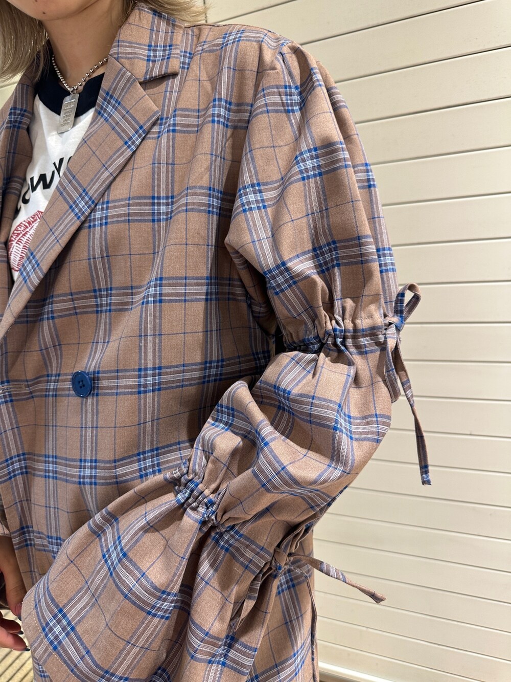 ベージュ系のワンピース、ホワイト系のTシャツ/カットソー、ブルー系のデニムパンツを着用したレディースの秋コーディネートの7枚目の写真