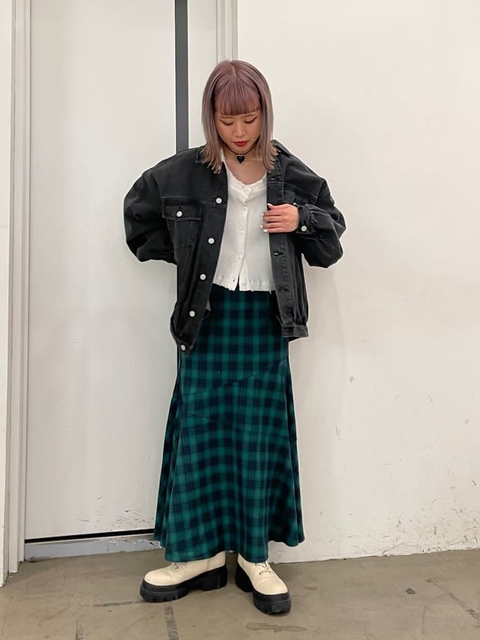 グリーン系のスカート、ブラック系のデニムジャケット、ホワイト系のブーツを着用したレディースの冬コーディネートの3枚目の写真