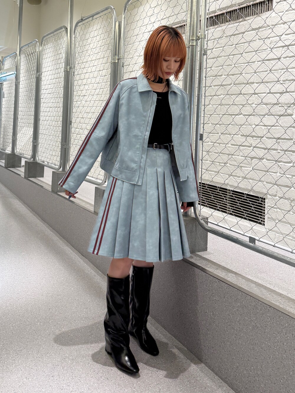 ブルー系のブルゾン、ブルー系のスカート、ブラック系のニット/セーターを着用したレディースの冬コーディネートの2枚目の写真