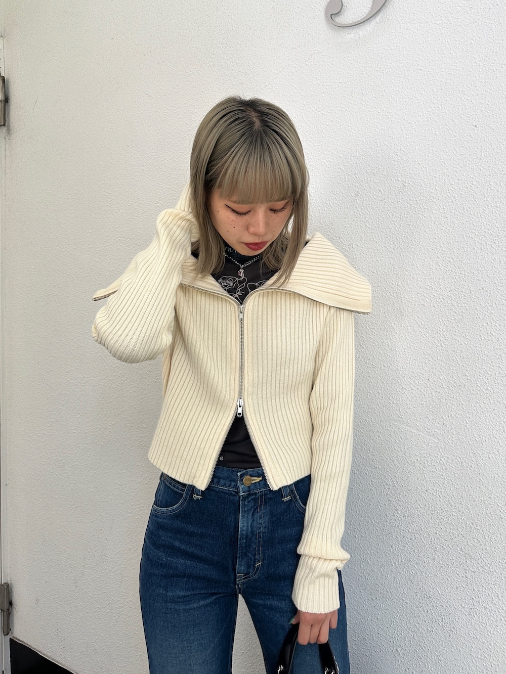 ブルー系のデニムパンツ、ホワイト系のカーディガン/ボレロ、ブラック系のTシャツ/カットソーを着用したレディースの冬コーディネートの4枚目の写真