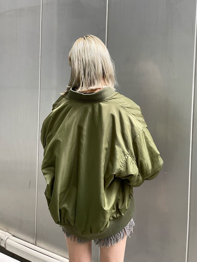 ブラック系のデニムパンツ、ベージュ系のMA-1、ブラック系のブーツを着用したレディースの秋コーディネートの6枚目の写真