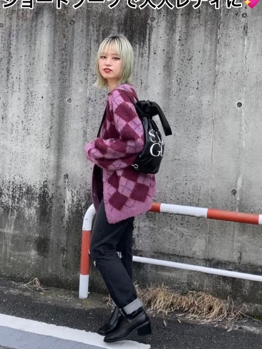 ブラック系のバックパック/リュック、ピンク系のカーディガン/ボレロ、ブラック系のブーツを着用したレディースの秋コーディネートの2枚目の写真