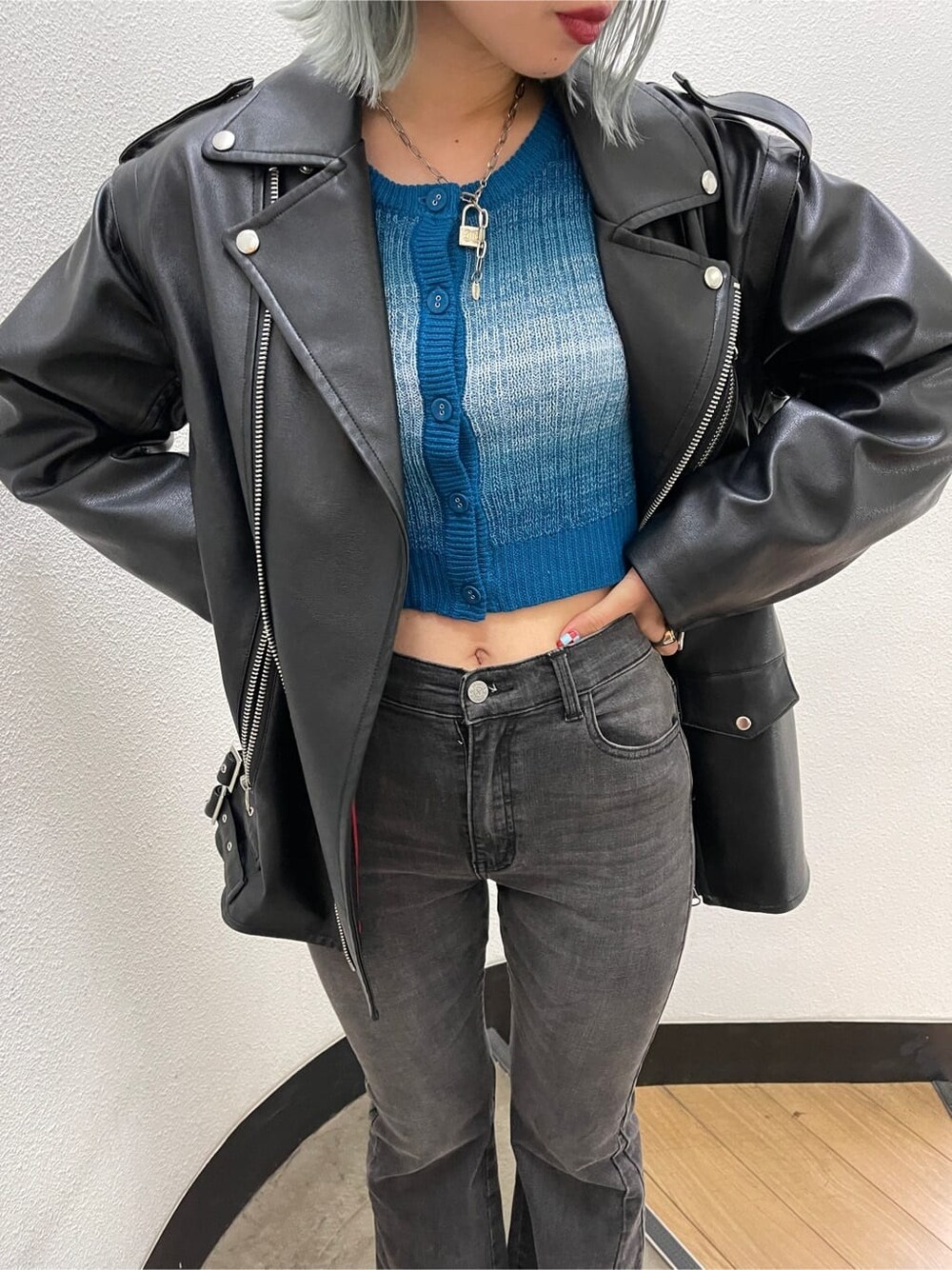 ブラック系のブーツ、ブラック系のライダースジャケット、ブルー系のカーディガン/ボレロを着用したレディースの秋コーディネートの7枚目の写真