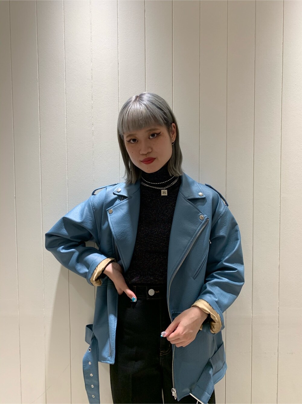 ブルー系のライダースジャケット、ブラック系のニット/セーター、ブラック系のデニムパンツを着用したレディースの秋コーディネートの2枚目の写真