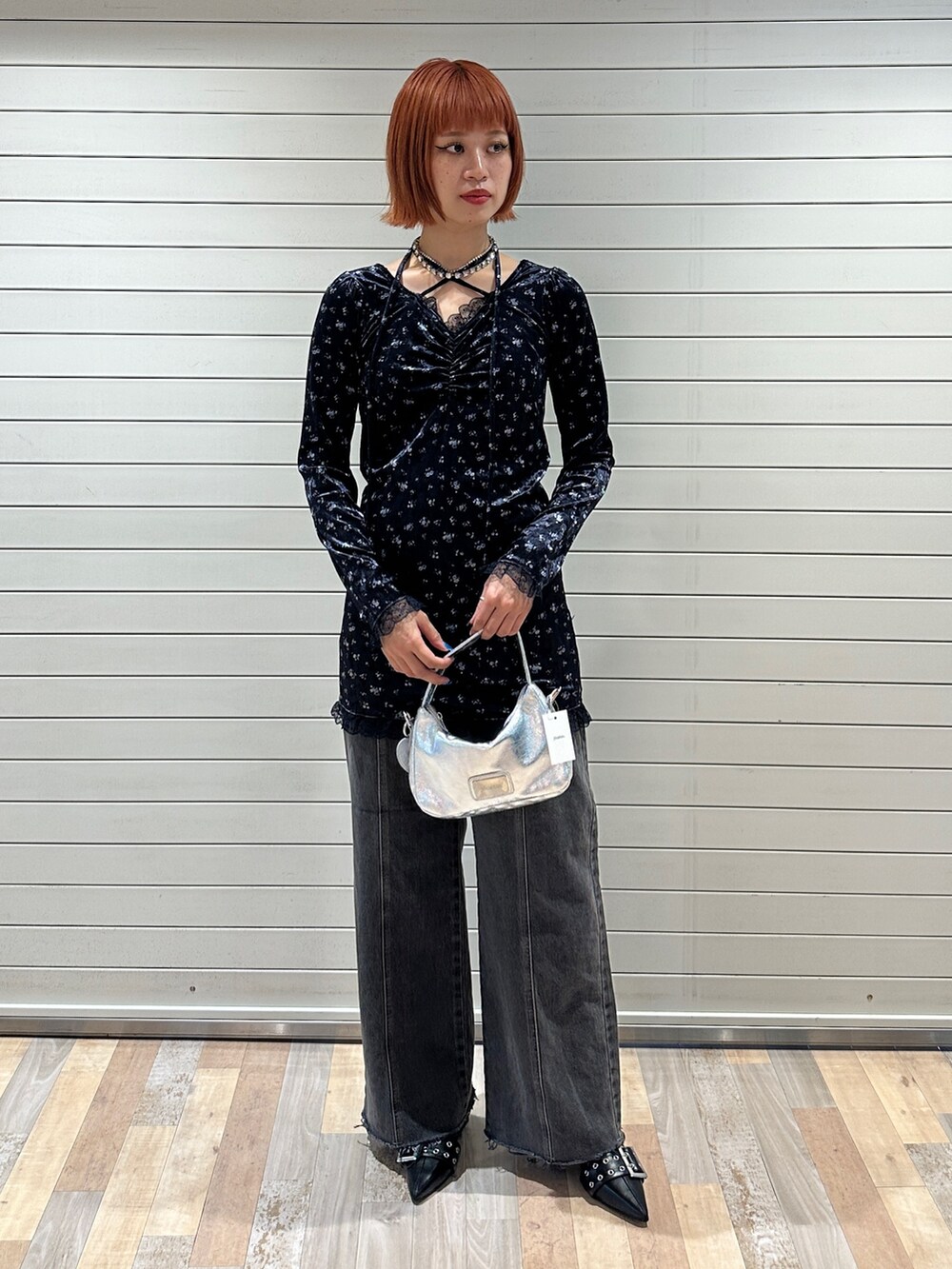 ブルー系のワンピース、シルバー系のハンドバッグ、ブラック系のデニムパンツを着用したレディースの冬コーディネートの5枚目の写真