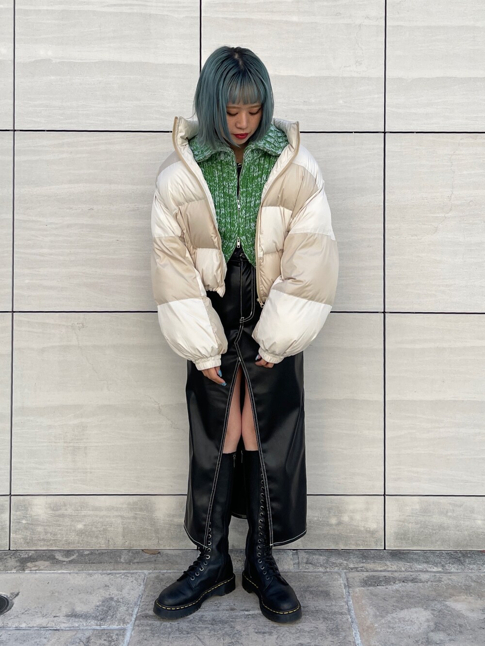 ホワイト系のTシャツ/カットソー、ブラック系のスカート、ブラック系のブーツを着用したレディースの秋コーディネートの2枚目の写真