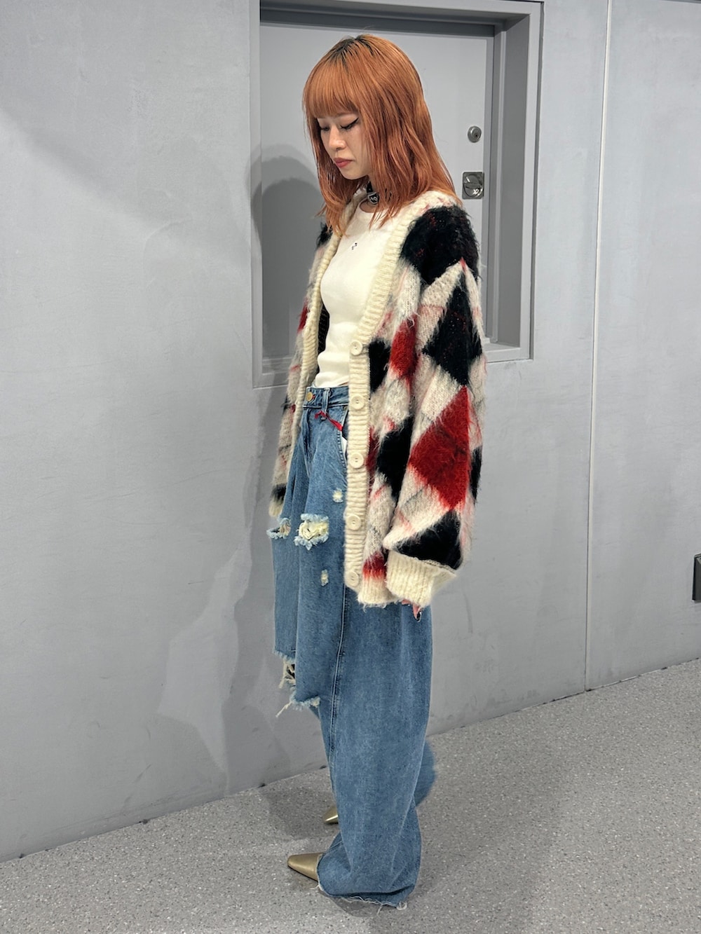 ブルー系のデニムパンツ、ホワイト系のカーディガン/ボレロ、ホワイト系のニット/セーターを着用したレディースの秋コーディネートの2枚目の写真