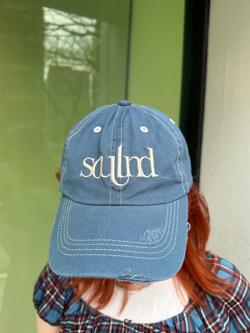 ブルー系のワンピース、ブラック系のスニーカー、ブルー系のキャップを着用したレディースの春コーディネートの6枚目の写真