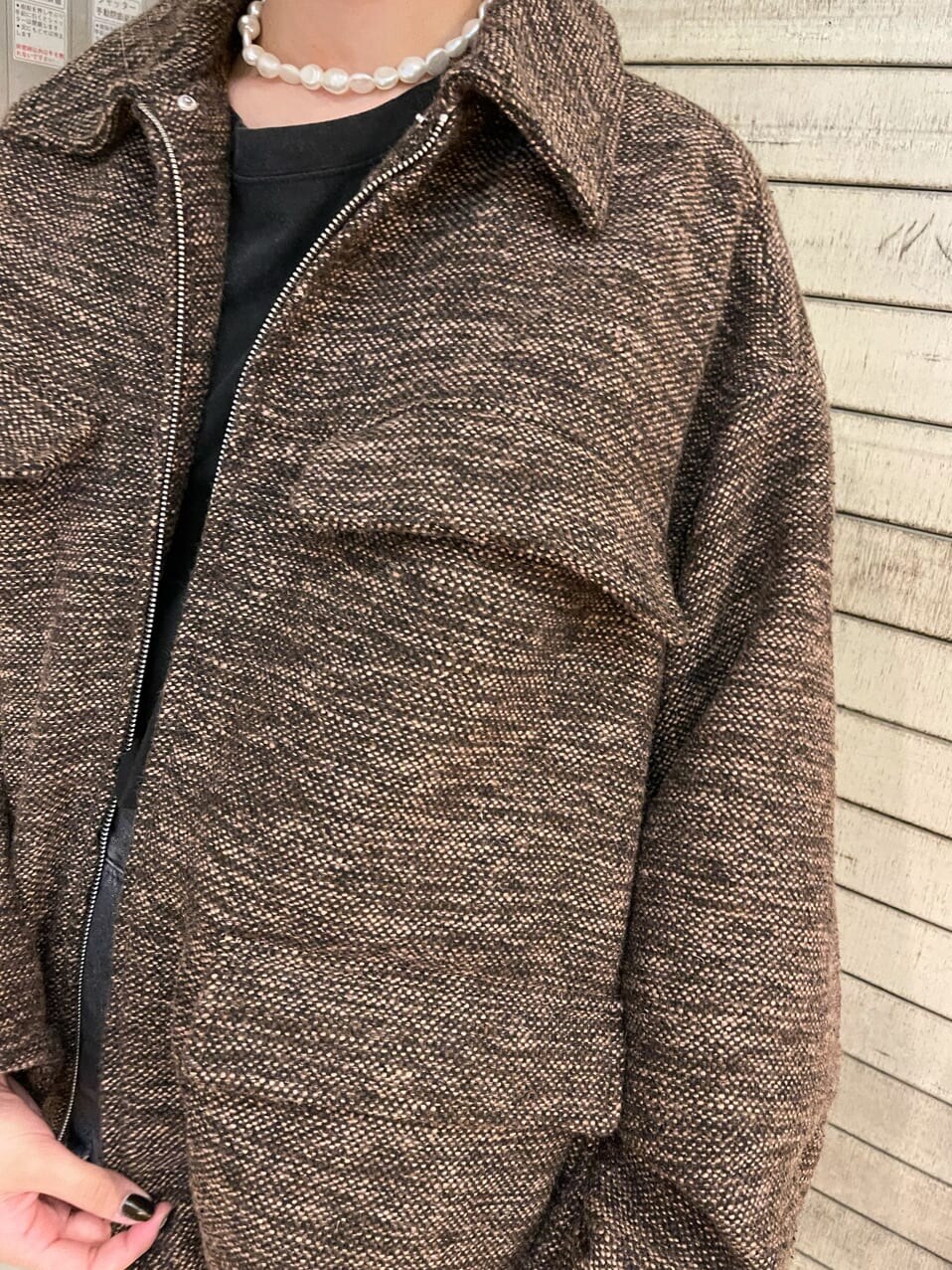 ブラック系のブーツ、ブラック系のデニムパンツ、ブラウン系のブルゾンを着用したレディースの夏コーディネートの6枚目の写真