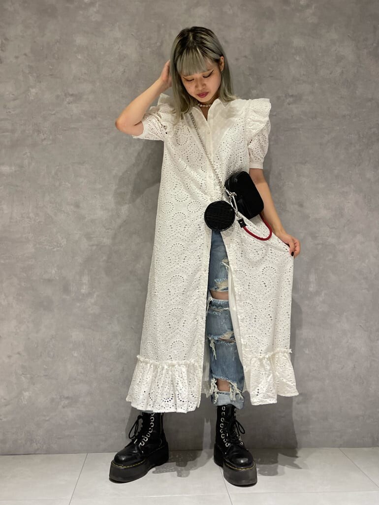 ホワイト系のワンピース、ブルー系のデニムパンツ、ブラウン系のショルダーバッグを着用したレディースの夏コーディネートの2枚目の写真