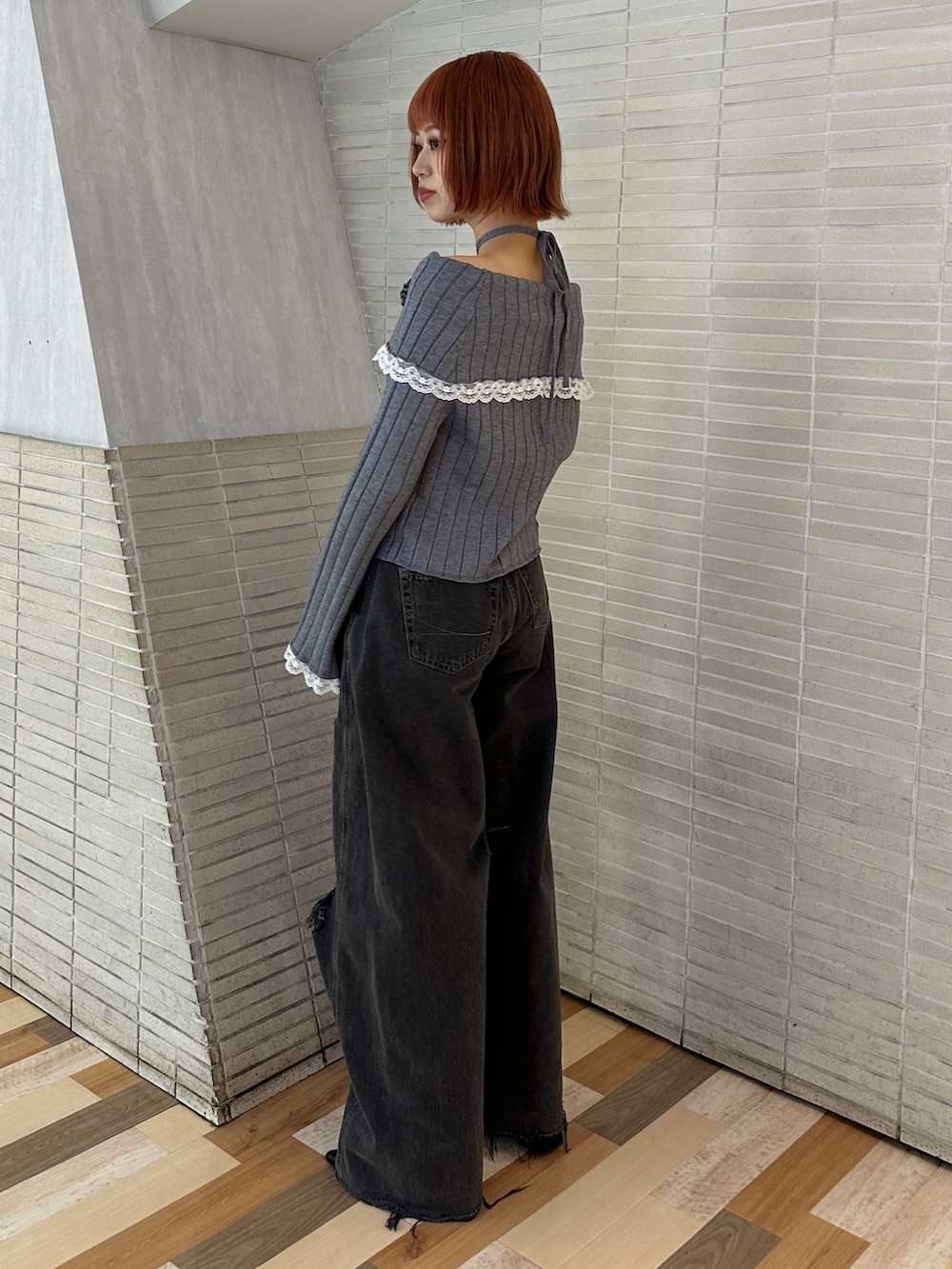 グレー系のニット/セーター、ブラック系のデニムパンツ、ブラック系のブーツを着用したレディースの冬コーディネートの4枚目の写真