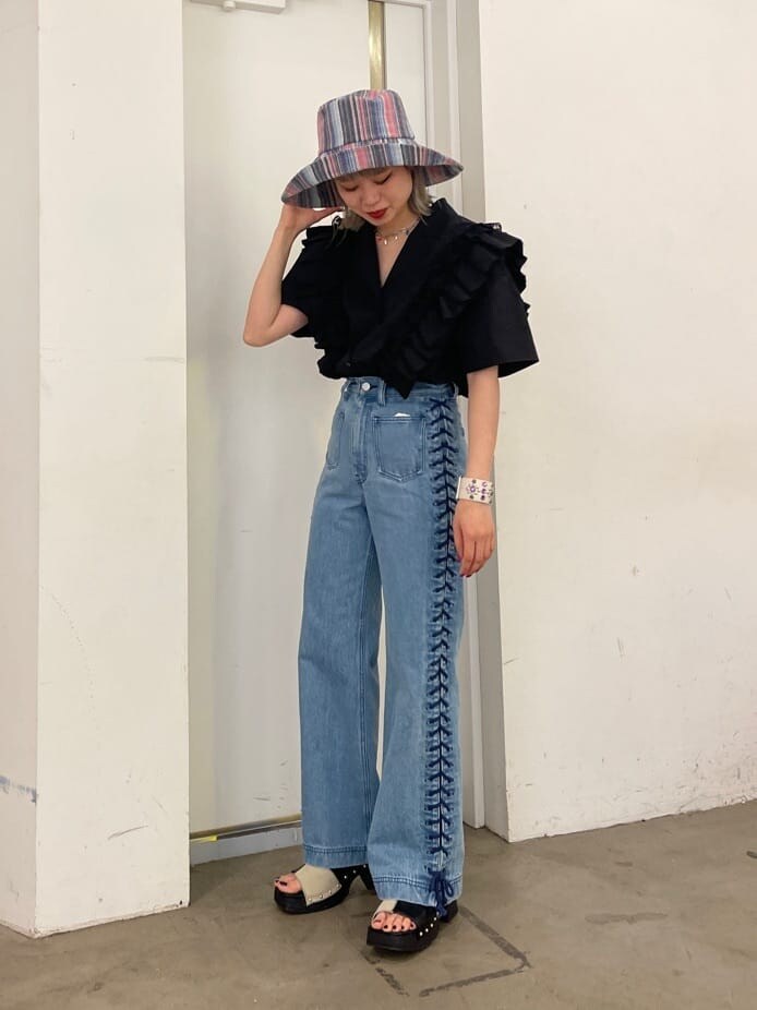 ブラック系のシャツ/ブラウス、ブラック系のサンダル、ブルー系のデニムパンツを着用したレディースの春コーディネートの2枚目の写真