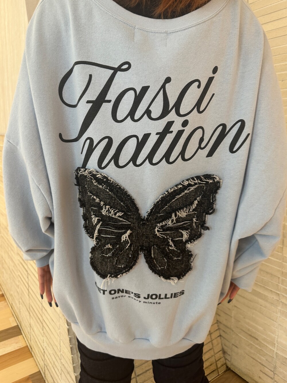 ブルー系のスウェット、ブラック系のパンプス、ブルー系のデニムパンツを着用したレディースの秋コーディネートの9枚目の写真