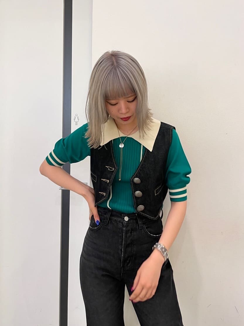 ブラック系のデニムパンツ、ブラック系のブーツ、ブラック系のベストを着用したレディースの春コーディネートの5枚目の写真