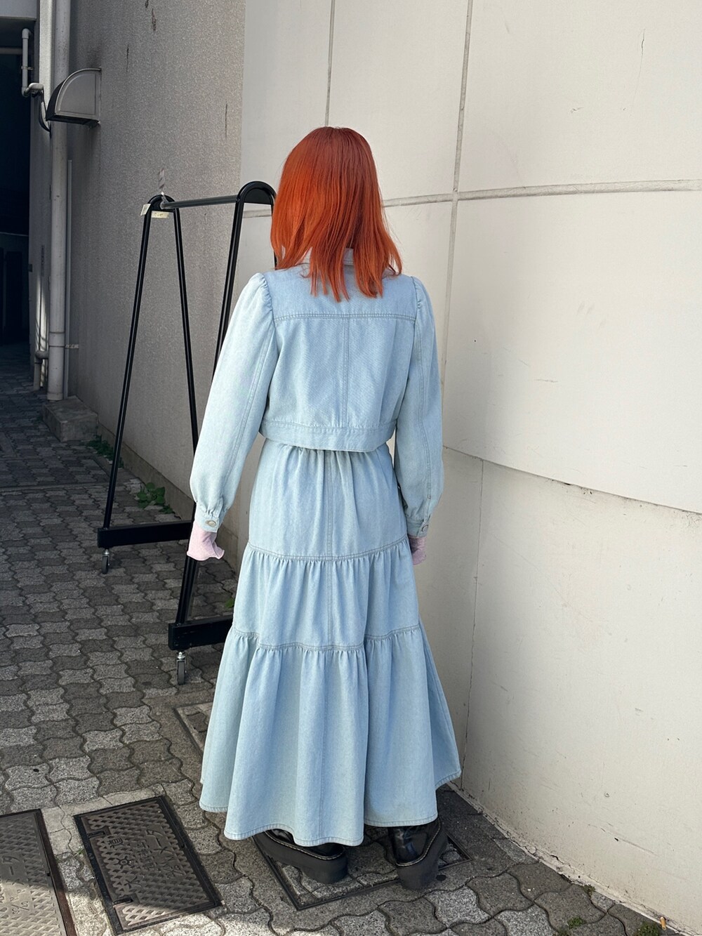 ブルー系のワンピース、ピンク系のTシャツ/カットソー、ブラック系のブーツを着用したレディースの冬コーディネートの4枚目の写真