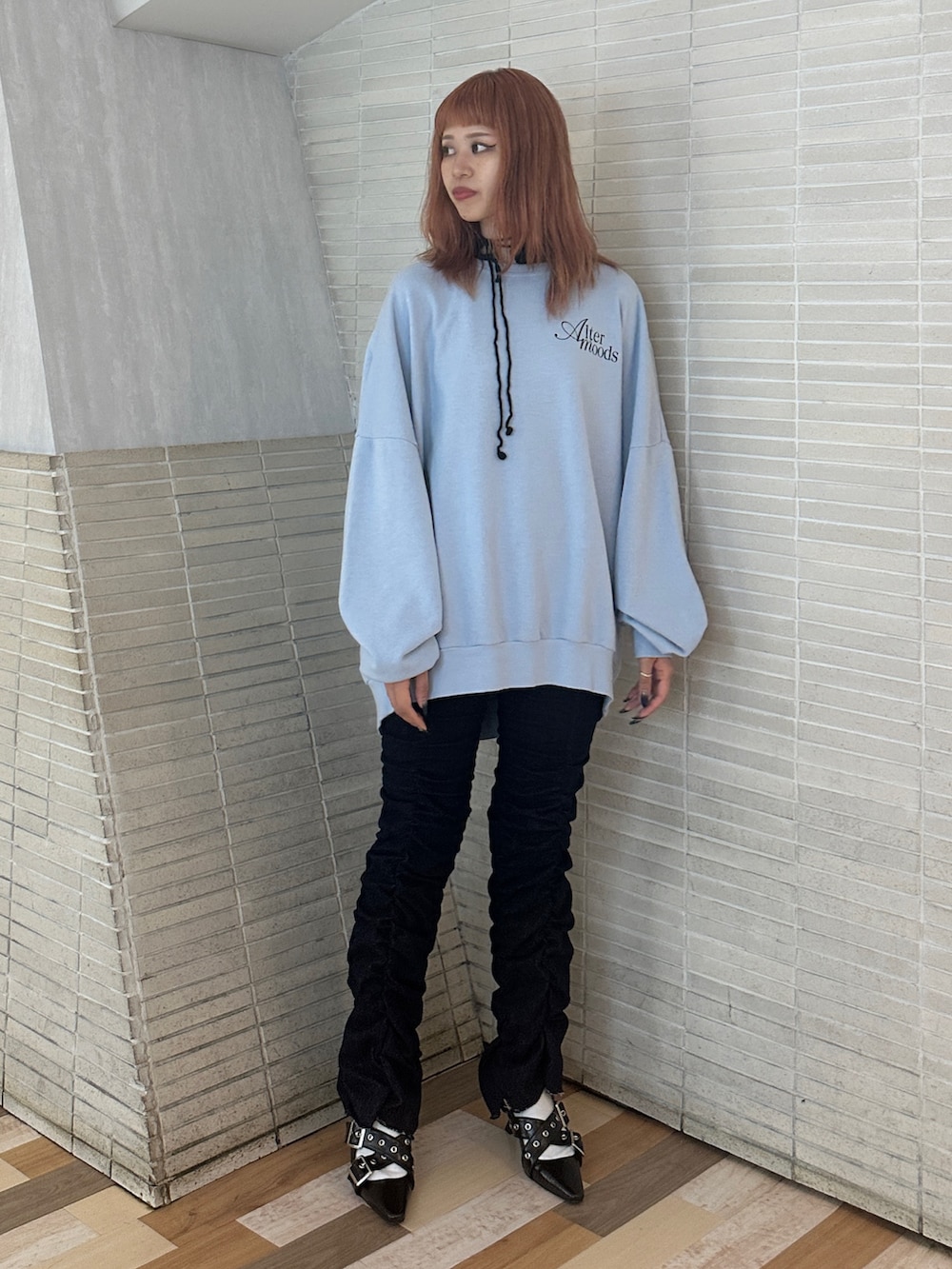 ブルー系のスウェット、ブラック系のパンプス、ブルー系のデニムパンツを着用したレディースの秋コーディネートの2枚目の写真