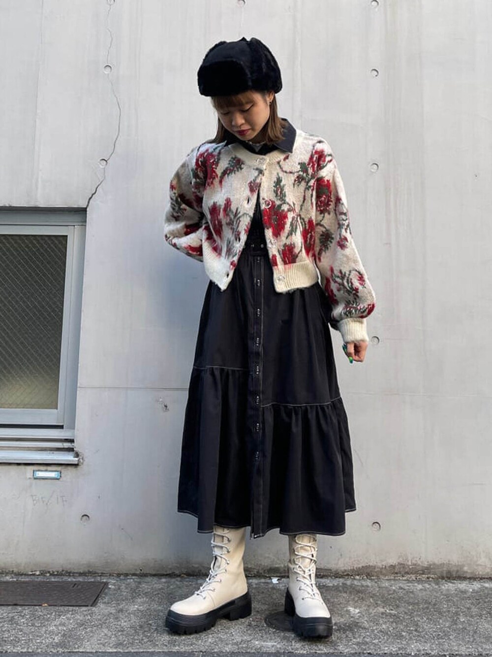 ホワイト系のブーツ、ブラック系のワンピース、ホワイト系のカーディガン/ボレロを着用したレディースの冬コーディネートの4枚目の写真