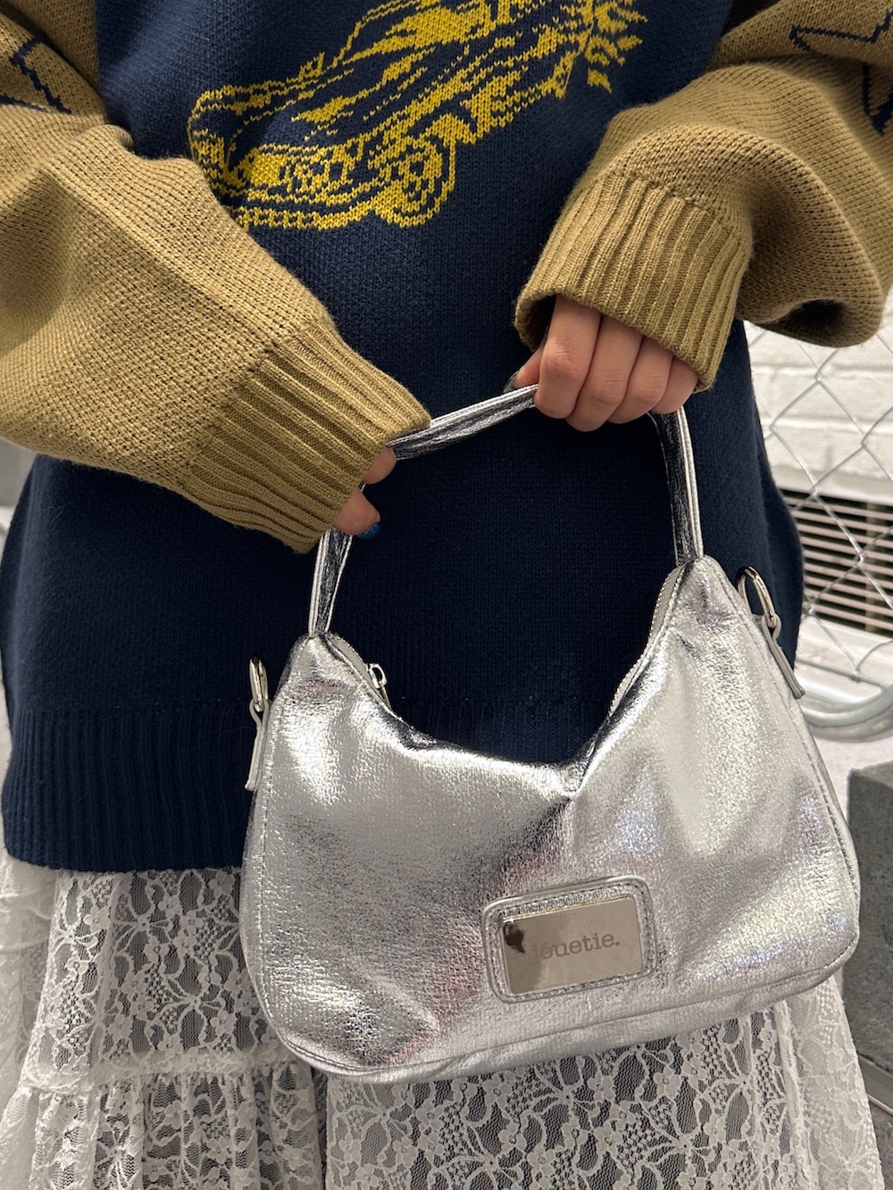 ブルー系のニット/セーター、ホワイト系のスカート、ブラック系のデニムパンツを着用したレディースの冬コーディネートの9枚目の写真