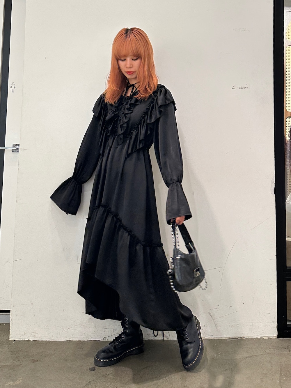 ブラック系のワンピース、ブラック系のハンドバッグ、ブラック系のブーツを着用したレディースの秋コーディネートの2枚目の写真