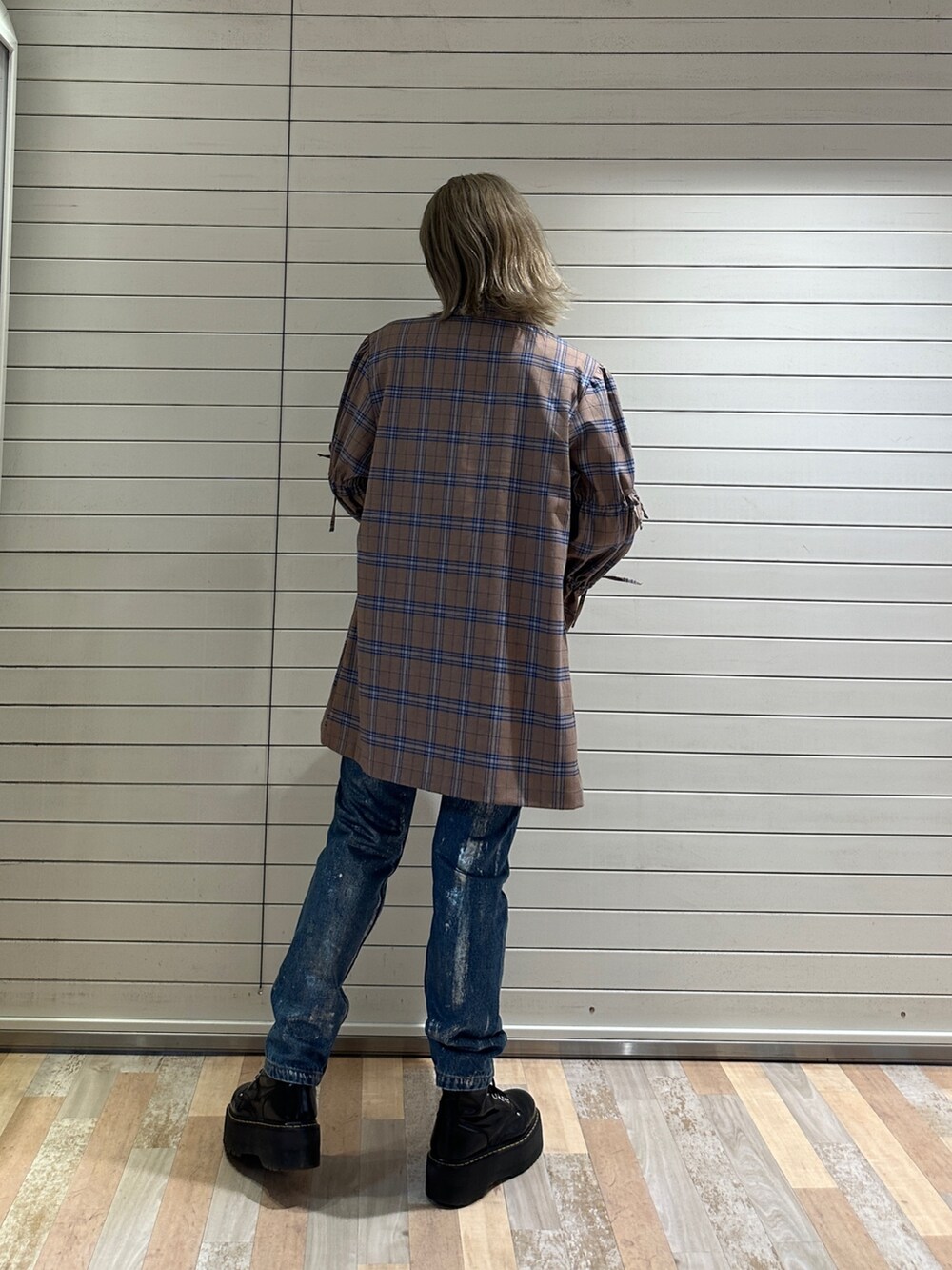 ベージュ系のワンピース、ホワイト系のTシャツ/カットソー、ブルー系のデニムパンツを着用したレディースの秋コーディネートの3枚目の写真