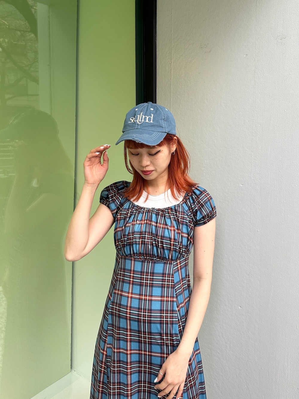 ブルー系のワンピース、ブラック系のスニーカー、ブルー系のキャップを着用したレディースの春コーディネートの5枚目の写真