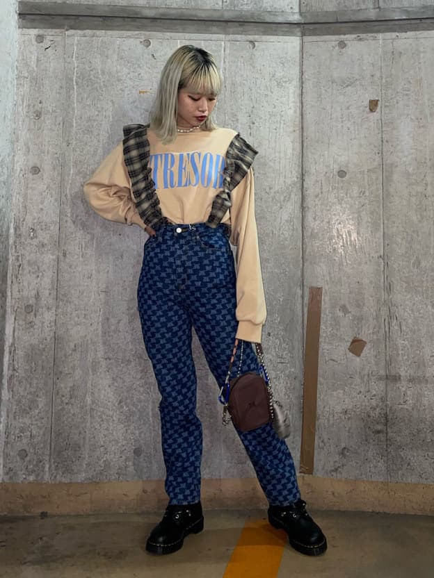 ブラウン系のショルダーバッグ、ベージュ系のTシャツ/カットソー、ブルー系のデニムパンツを着用したレディースの秋コーディネートの2枚目の写真