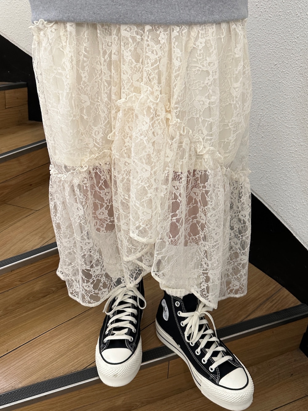 グレー系のパーカー、ホワイト系のスカート、ブラック系のスニーカーを着用したレディースの秋コーディネートの10枚目の写真