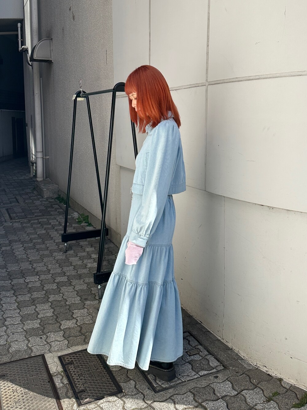 ブルー系のワンピース、ピンク系のTシャツ/カットソー、ブラック系のブーツを着用したレディースの冬コーディネートの3枚目の写真