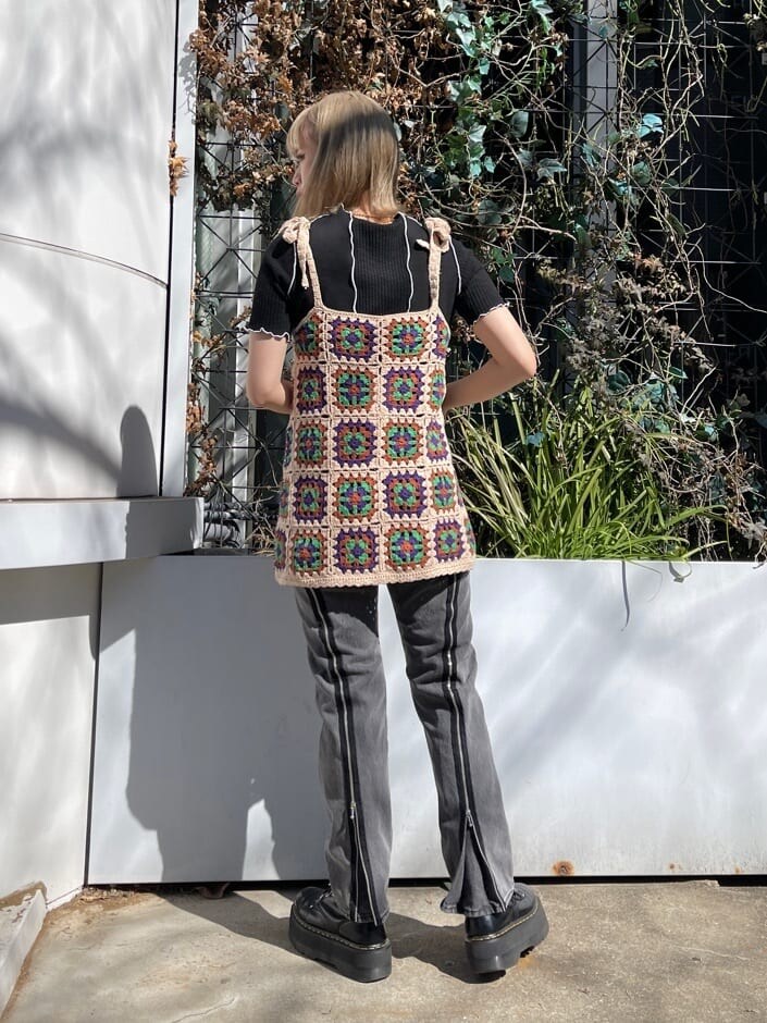 ベージュ系のニット/セーター、ブラック系のTシャツ/カットソー、ブラック系のデニムパンツを着用したレディースの春コーディネートの4枚目の写真