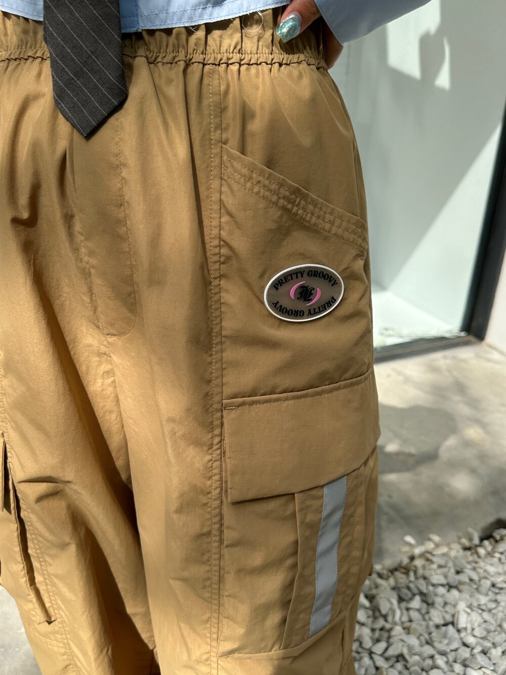 ベージュ系のカーゴパンツ、ブラック系のスニーカー、シルバー系のハンドバッグを着用したレディースの春コーディネートの8枚目の写真