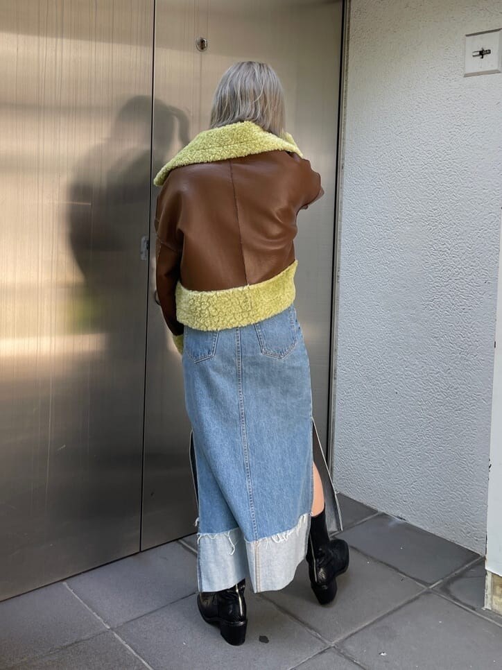 ブラック系のブーツ、ブラウン系のその他アウター、ブルー系のデニムスカートを着用したレディースの夏コーディネートの3枚目の写真