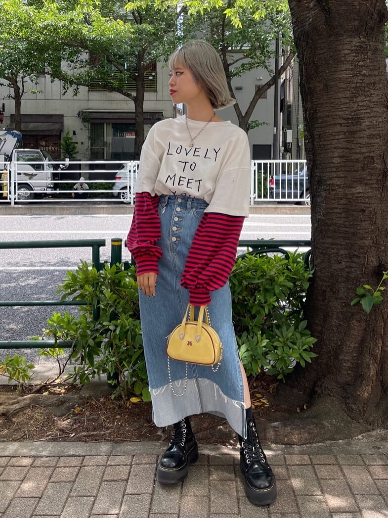 ブラック系のその他シューズ、イエロー系のボストンバッグ、ブルー系のデニムスカートを着用したレディースの夏コーディネートの2枚目の写真