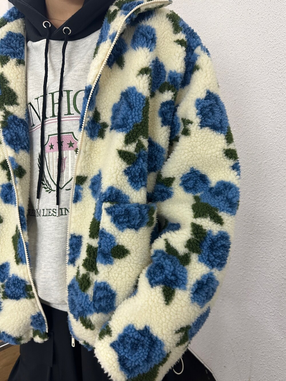 ホワイト系のブルゾン、グレー系のパーカー、ブラック系のその他パンツを着用したレディースの秋コーディネートの6枚目の写真