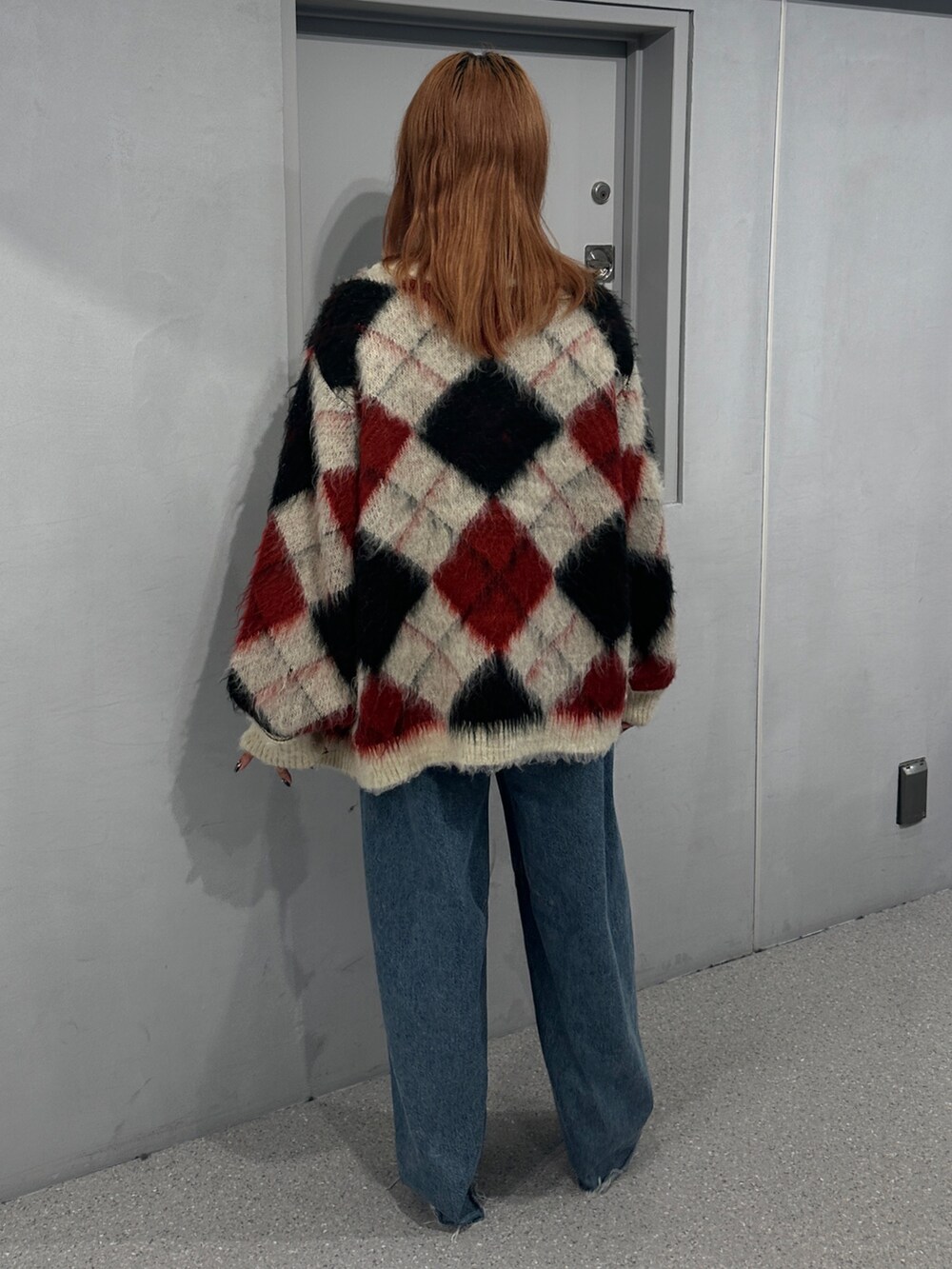 ブルー系のデニムパンツ、ホワイト系のカーディガン/ボレロ、ホワイト系のニット/セーターを着用したレディースの秋コーディネートの3枚目の写真