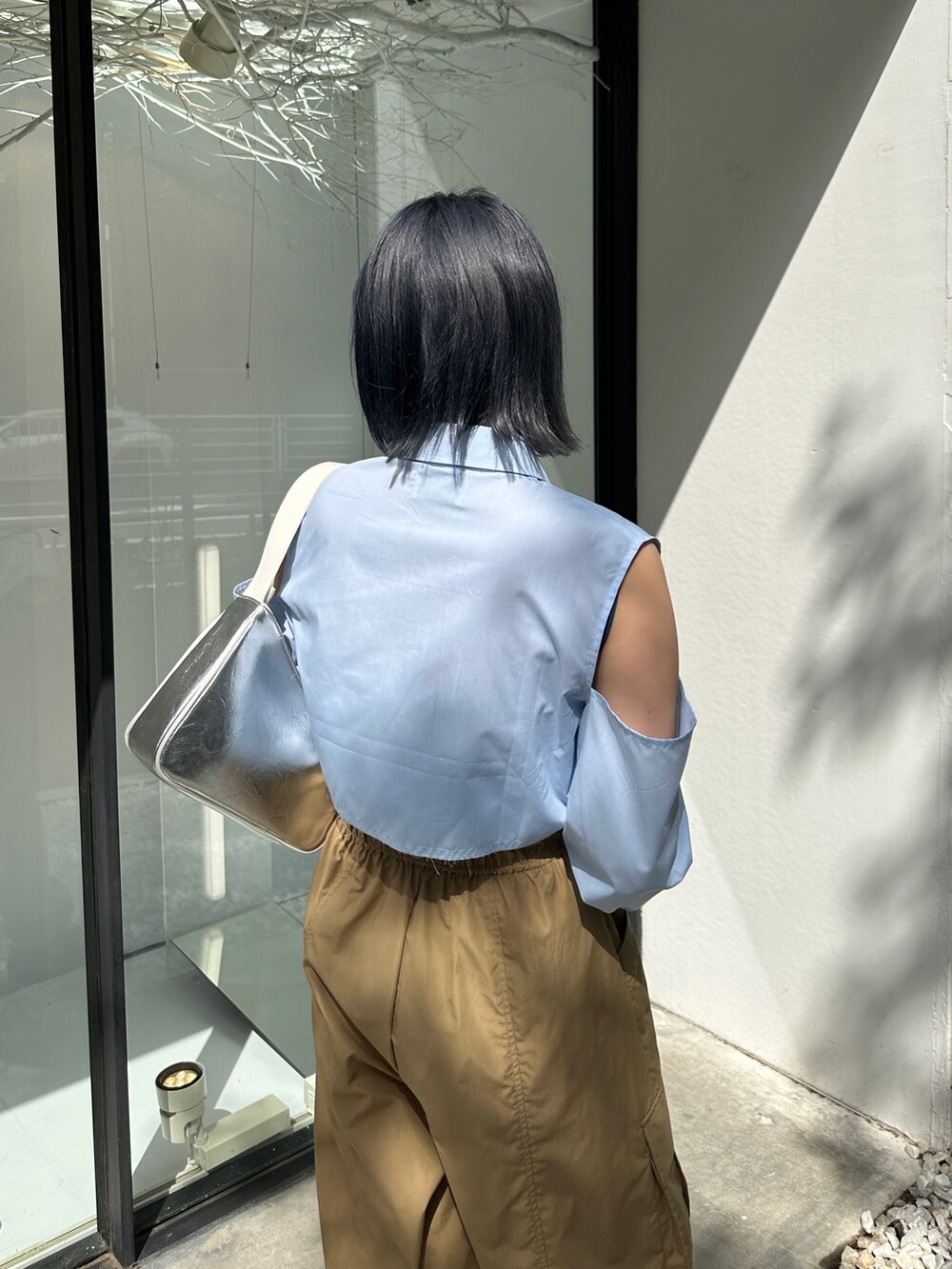 ベージュ系のカーゴパンツ、ブラック系のスニーカー、シルバー系のハンドバッグを着用したレディースの春コーディネートの5枚目の写真