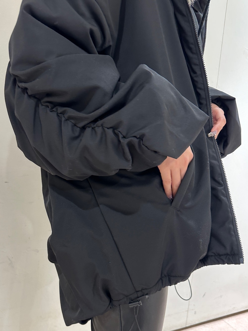 ブラック系のその他パンツ、ブラック系のその他アウター、ピンク系のニット/セーターを着用したレディースの冬コーディネートの8枚目の写真