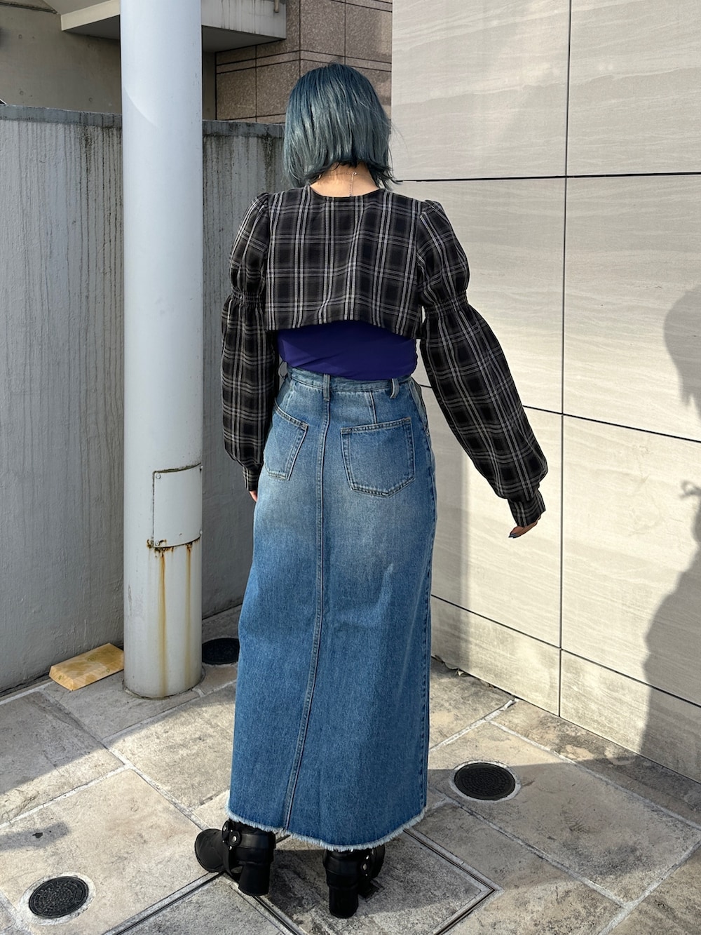 ブルー系のスカート、パープル系のTシャツ/カットソー、ブラック系のワンピースを着用したレディースの冬コーディネートの3枚目の写真