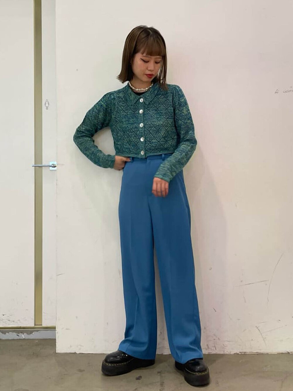 ブルー系のスラックス、グリーン系のシャツ/ブラウス、シルバー系のチョーカーを着用したレディースの冬コーディネートの3枚目の写真