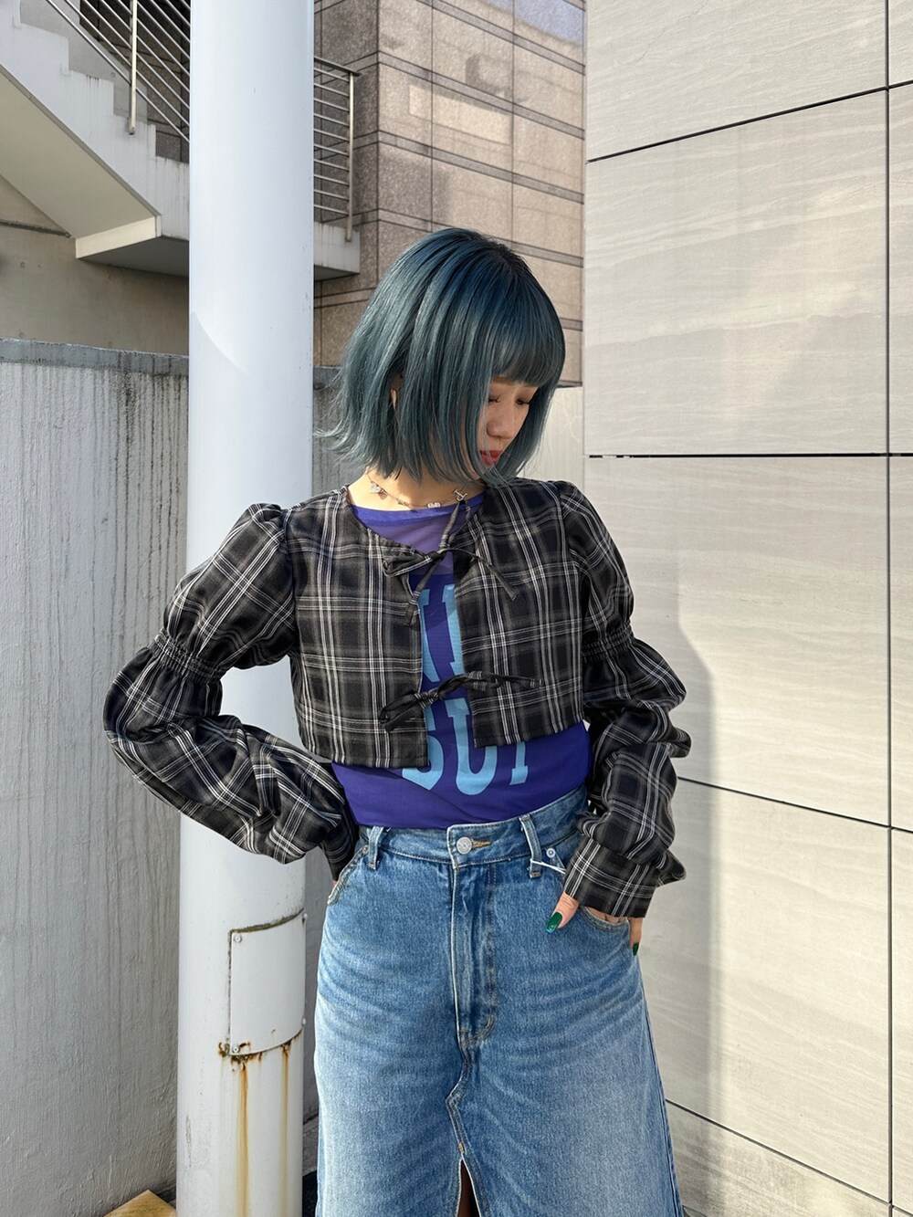 ブルー系のスカート、パープル系のTシャツ/カットソー、ブラック系のワンピースを着用したレディースの冬コーディネートの4枚目の写真