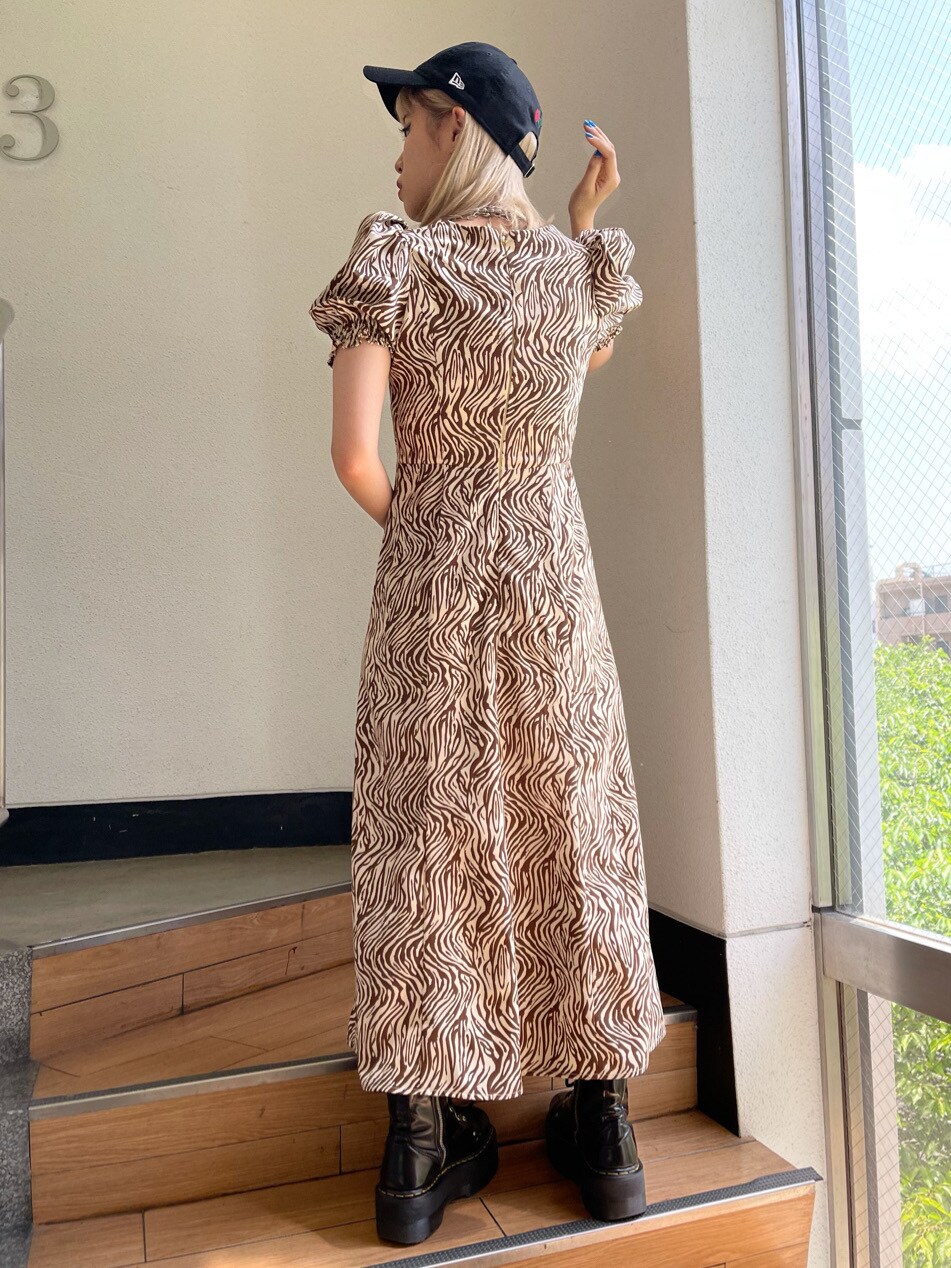 ホワイト系のワンピース、ブラック系のキャップを着用したレディースの春コーディネートの3枚目の写真